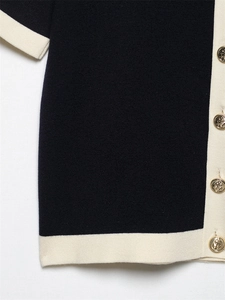 Detail of navy knit cardigan with gold anchor buttons and contrasting white trim