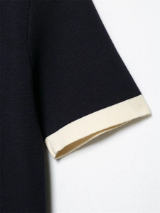 Detailed macro view of the navy blue knit sleeve cuff with contrast cream trim