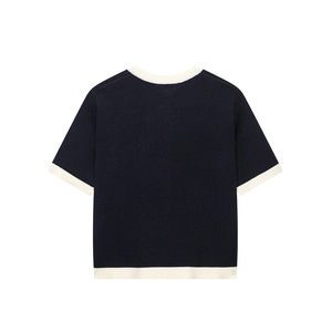 Detail of short sleeve knit cardigan with contrast trim and navy blue textured fabric