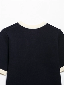 Close-up of navy knit cardigan with cream contrast trim on neckline and shoulder
