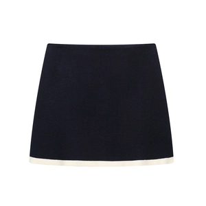 Elegant black knit mini skirt with white contrast trim and minimalist A-line silhouette