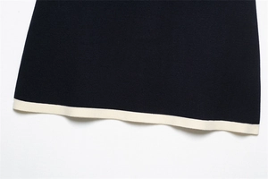 Detailed view of the dark blue knit hem with ivory contrast piping and textured fabric
