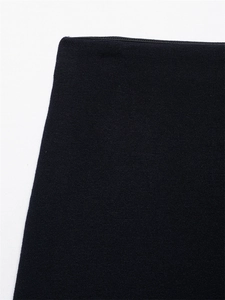 Macro shot of dark navy knit fabric texture and waistband seam on elegant mini skirt