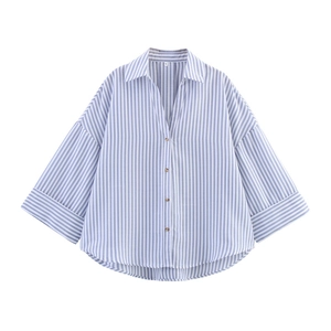 Détail du col d'une chemise rayée bleue et blanche et fermeture à boutons marron