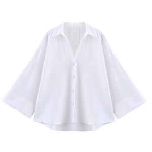 Gros plan sur les manches cloche évasées et la texture de cette chemise blanche en lin