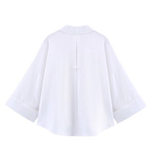 Détail du dos d'une chemise blanche en lin avec un pli et une sangle horizontale