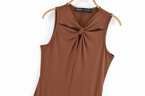 Detailansicht eines braunen ärmellosen Kleides mit Knotendetail und Cut-out-Ausschnitt