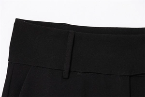 Detail of wide high-waist band on black wide-leg trousers with premium matte texture