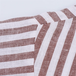 Gros plan détaillé montrant les coutures et la texture du lin sur la chemise rayée