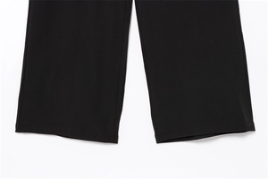 Detailed close-up showing neat stitching and wide-leg hem of black suit trousers
