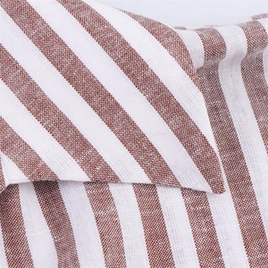 Détail du tissu rayé marron et blanc en mélange de lin sur le col d'une chemise