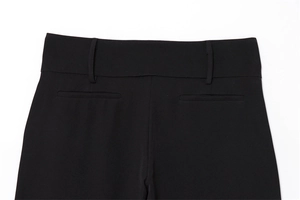 Detailed view of black wide-leg trousers featuring a wide waistband and welt back pockets