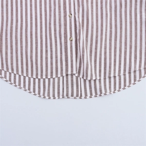 Gros plan détaillé de la chemise en lin à rayures brunes avec boutons et ourlet arrondi