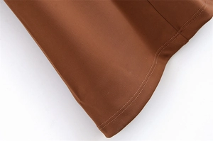 Detailaufnahme des braunen Strickkleid-Saums mit professioneller Doppelnadel-Steppnaht