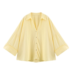 Détail d'une chemise jaune clair en mélange de lin avec col en V et boutons contrastés