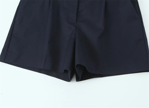 Dettaglio di pantaloncini casual blu navy a vita alta con pieghe e tasche laterali