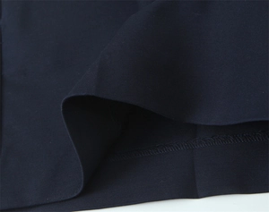 Vista macro dettagliata dei pantaloncini a pieghe blu scuro che mostra la cucitura a sopraggitto