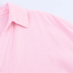 Détail de la texture respirante en coton lin et coutures du col sur la chemise rose