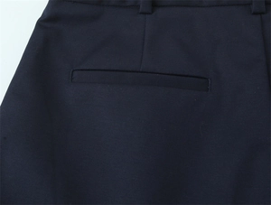 Dettaglio della tasca a filo posteriore e del passante per cintura sui pantaloni blu scuro