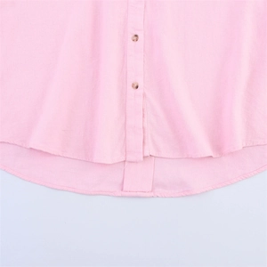 Détail d'une chemise rose en mélange de lin avec boutons marron et ourlet arrondi
