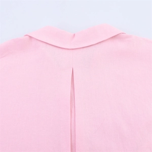 Détail d'une chemise en lin rose clair avec col classique et pli d'aisance au dos