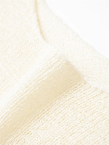 Vue macro du tricot crème avec texture en maille respirante et coutures de qualité