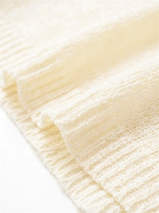 Gros plan sur la texture de maille côtelée délicate et le tissu crème doux
