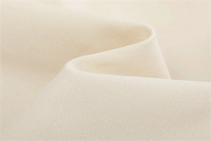 Detailed macro shot of beige twill fabric texture with high-quality weave and soft draping