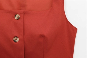 Detail of square neck brick red sleeveless top featuring brown tortoiseshell buttons