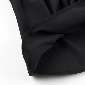 Close-up of precise stitching and hem detail on a black sleeveless minimalist top