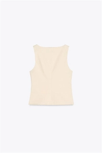 Detail view of cream sleeveless vest with structured fabric and back seam line