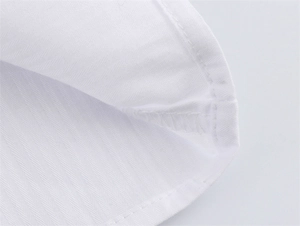 Makroaufnahme der präzisen Kantennähte und Baumwollstoff-Details der weißen Bluse