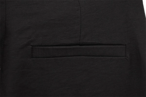 Vue détaillée d'une poche passepoilée sur un pantalon large noir en sergé à taille haute