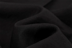 Vue macro détaillée du tissu sergé noir de qualité avec plis doux et texture fine