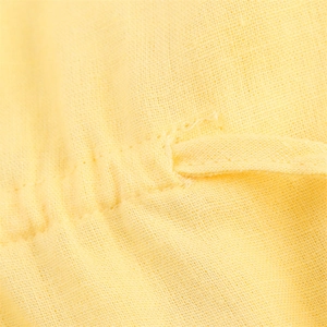 Gros plan du tissu en coton et lin jaune vif montrant les coutures et la texture tissée