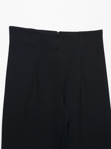 Dettaglio dei pantaloni neri a vita alta con cerniera invisibile e trama del tessuto