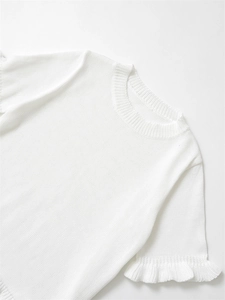 Vue détaillée d'un haut en tricot blanc avec manches à volants élégantes et texture fine