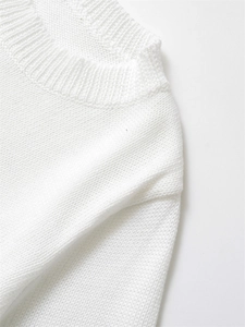 Détail du col rond à fines côtes sur un pull en maille blanc pour femme chic
