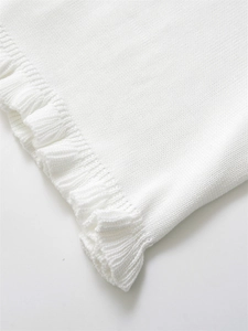 Détail de la maille blanche montrant la texture douce et les bords ondulés délicats