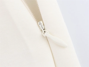 Detailansicht des unsichtbaren Reißverschlusses an der cremeweißen Hose aus Webstoff