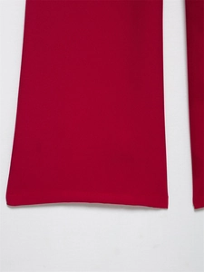 Dettaglio dell'orlo sui pantaloni rosso scuro con trama di tessuto a navetta di alta qualità