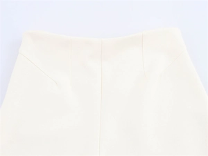 Detailansicht der cremeweißen Hose mit Fokus auf die präzise Taillennaht und Schnittform