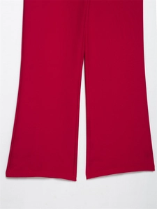 Dettaglio dell'orlo a gamba larga di pantaloni rosso scuro con tessuto fluido