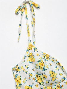 Detalle de vestido de popelina floral con flores amarillas y azules y tirantes anudados