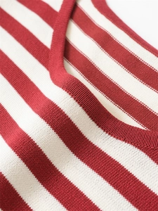 Gros plan sur la maille rayée rouge et blanche au col d'un t-shirt d'été pour femmes