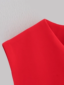 Dettaglio del gilet rosso che mostra la trama in saia e le rifiniture dei bordi