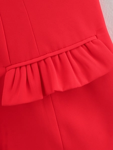Dettaglio del gilet rosso che mostra volant, trama in twill e finiture in piping curato
