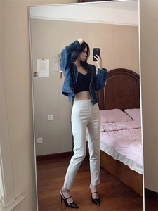 Pantaloni beige a vita alta da donna con décolleté nere a punta e tacco sottile