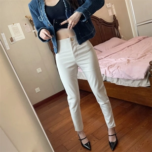Dettaglio dei leggings a vita alta color crema slim fit con un bottone singolo in metallo dorato