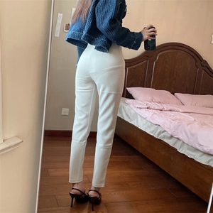 Dettaglio dei pantaloni bianchi a vita alta con taglio dritto e stile professionale